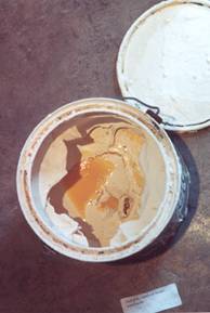 Wedding ring embedded in dregs of primer at bottom of paint can.